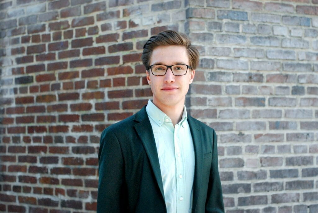 Johan ANdersson framför en tegelvägg