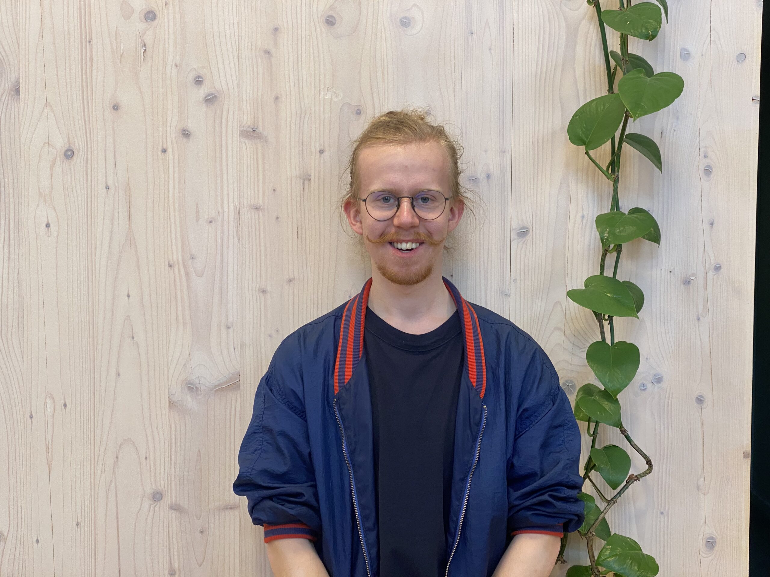 Alexander Ahl framför en ljus trävägg